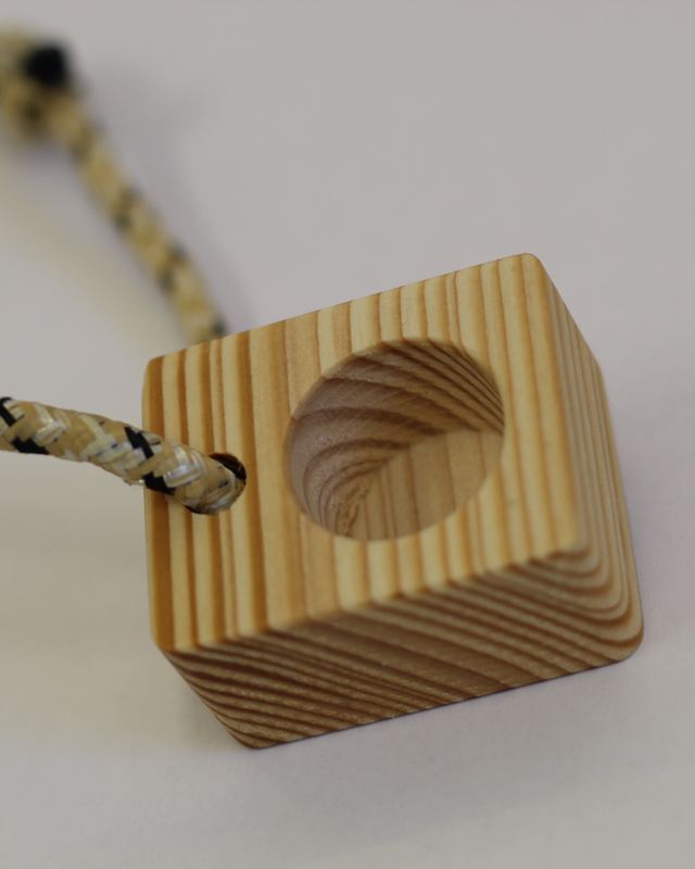 Wooden mono finger trainer with its cord, pocket seen at an angle
