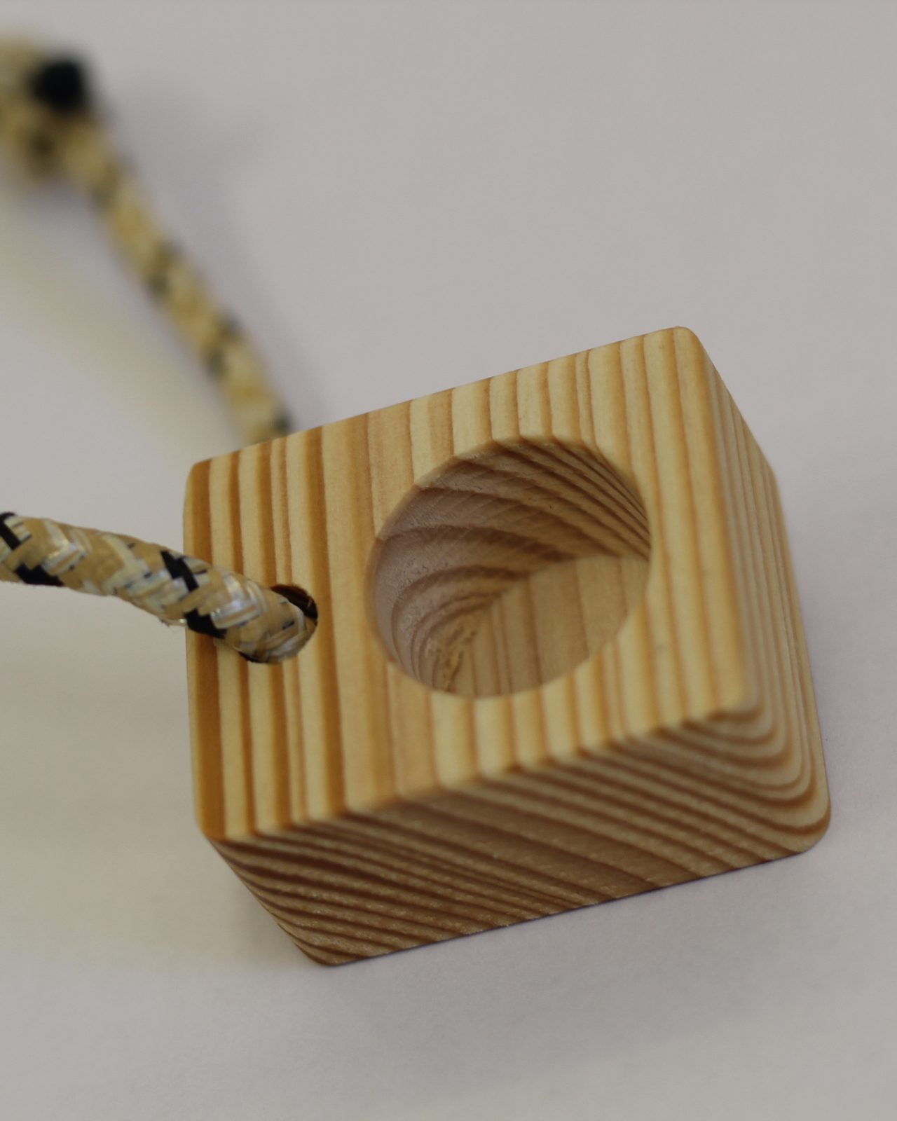 Mono dito in legno con il cordino, il buco visto di tre quarti